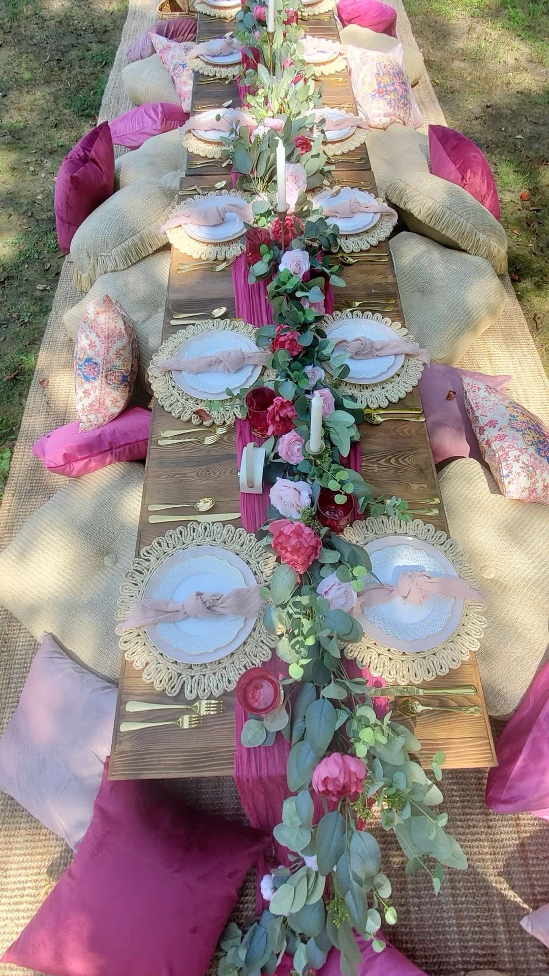 Long bohemian tablescape with pink runners and floral garlands