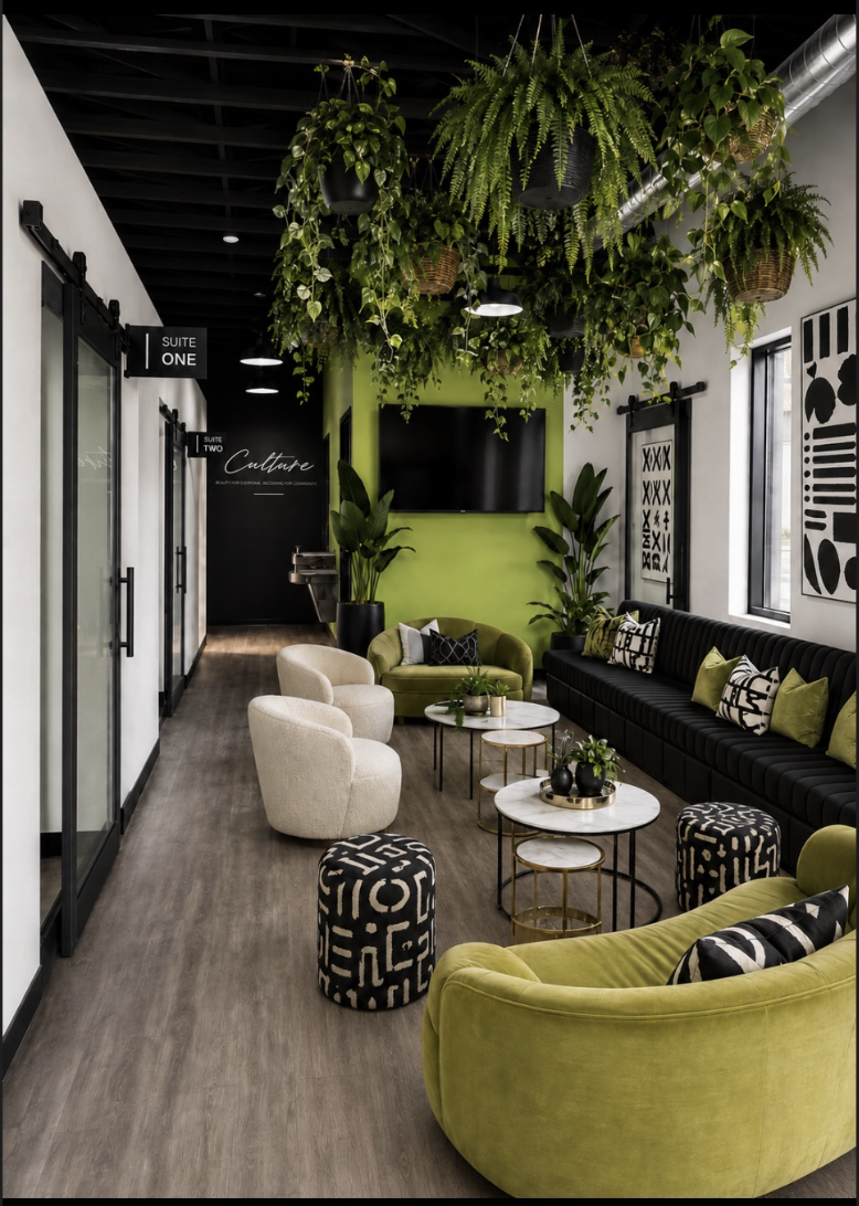 The Culture lounge with green velvet seating, hanging plants, and private suite doors